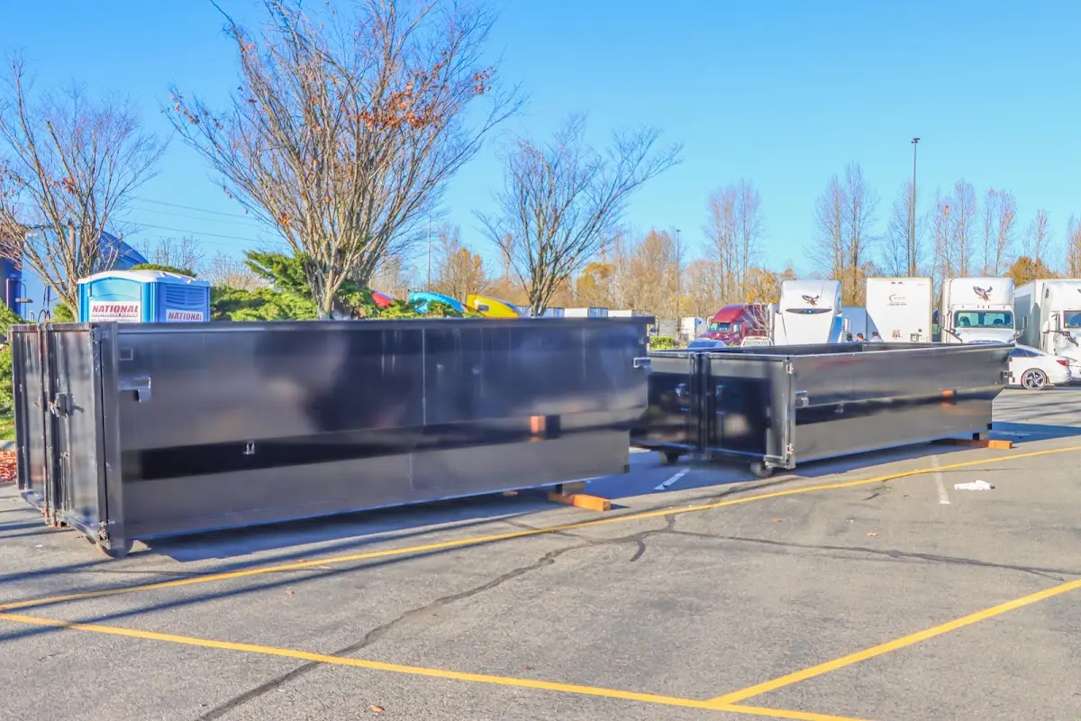 Professional dumpster rental service with roll-off container on residential driveway in Prosser